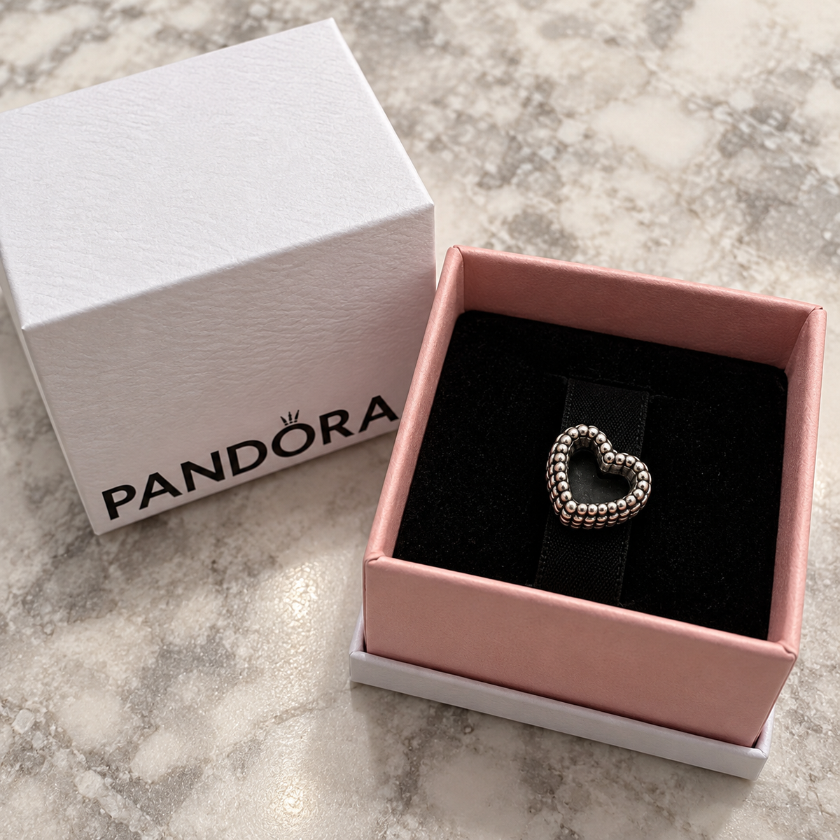 Pandora beaded heart charm displayed in its pink and white box