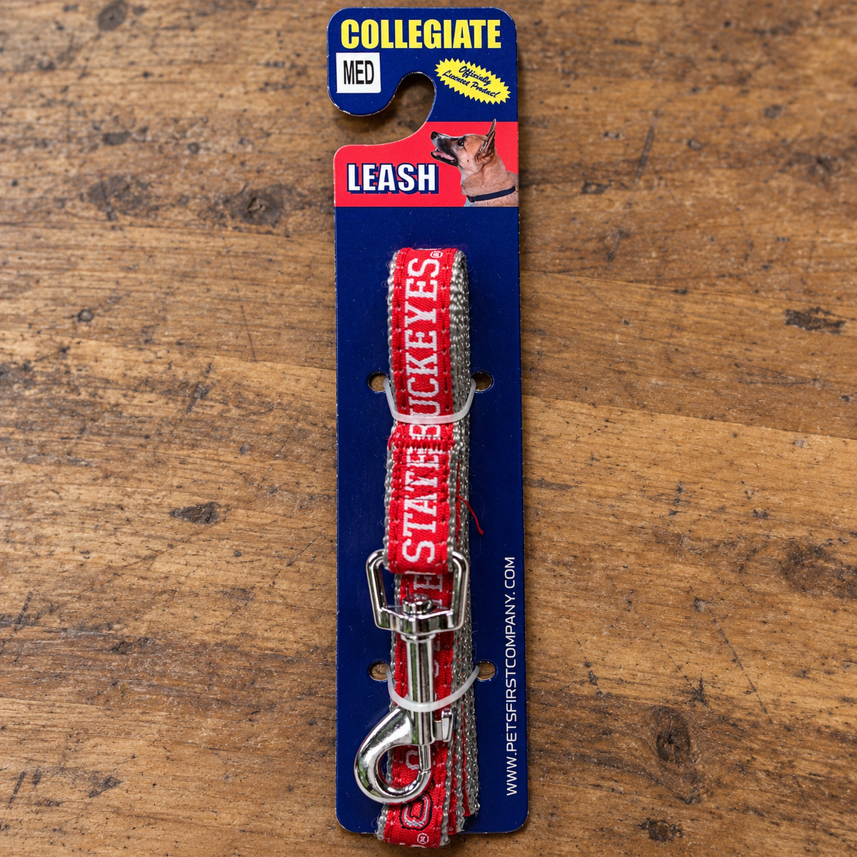 AI-generated lifestyle illustration of one packaged Pets First ohio medium gear table collegiate leash; background props not included.