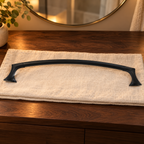 Pfister Rhen matte black towel bar displayed on linen beside a bathroom vanity