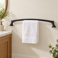 Pfister Rhen matte black towel bar shown in an ivory bathroom with a white hand towel