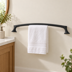 Pfister Rhen matte black towel bar shown in an ivory bathroom with a white hand towel