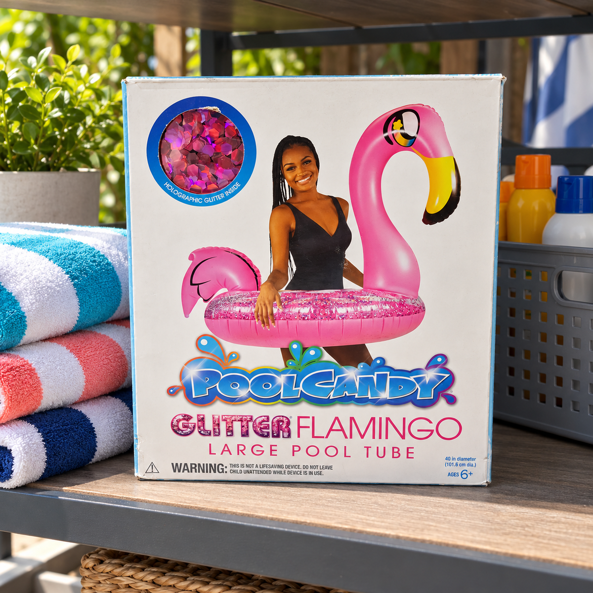 AI-generated lifestyle scene of one closed PoolCandy Glitter Flamingo 40-inch pool tube box in a supply shelf setting. Props not included.