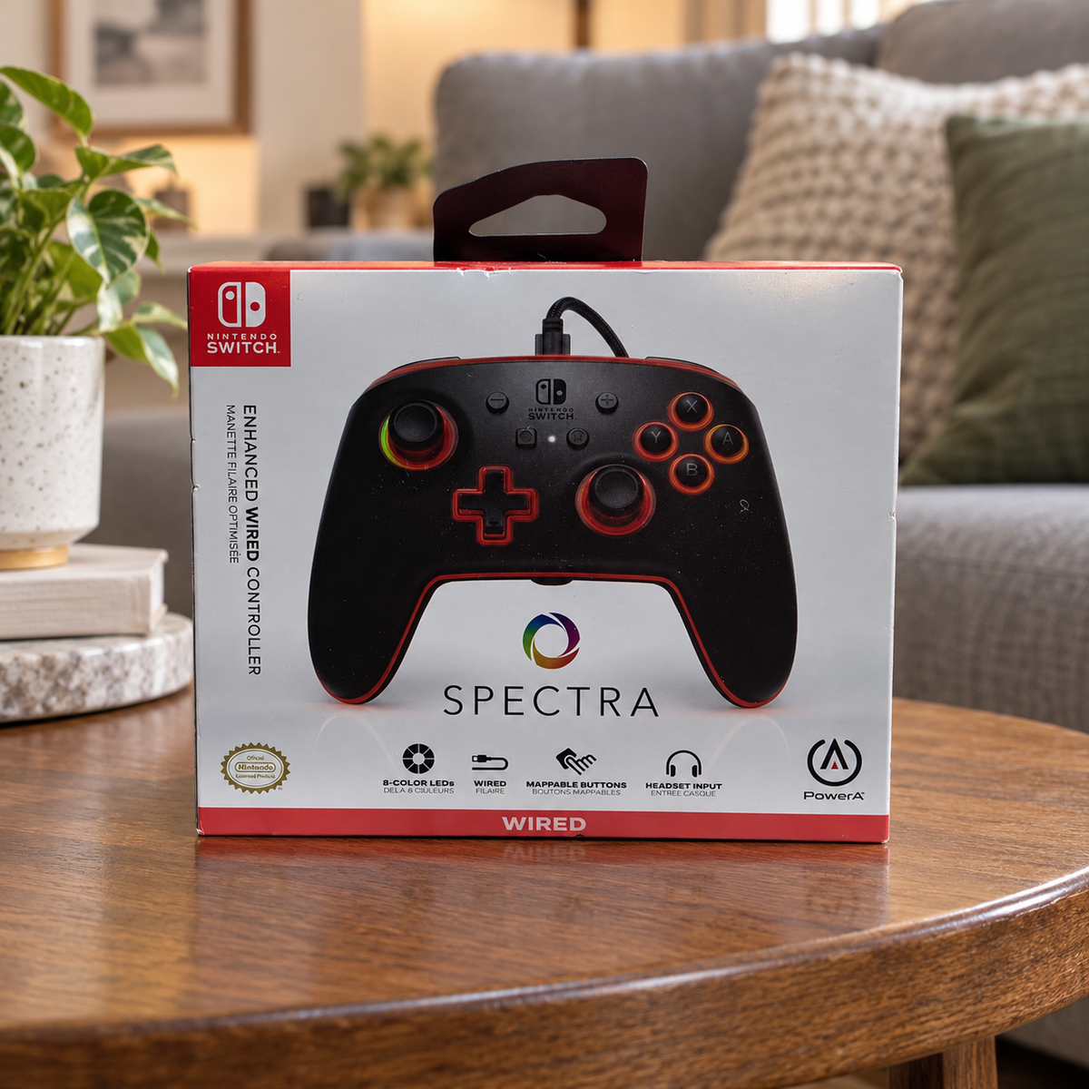 AI-generated lifestyle scene of one closed PowerA Spectra Nintendo Switch wired controller retail box in a living room table setting. Props not included.