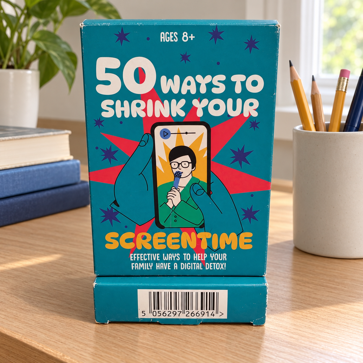AI-generated lifestyle scene of the closed 50 Ways to Shrink Your Screentime package in a study desk setting. Props not included.