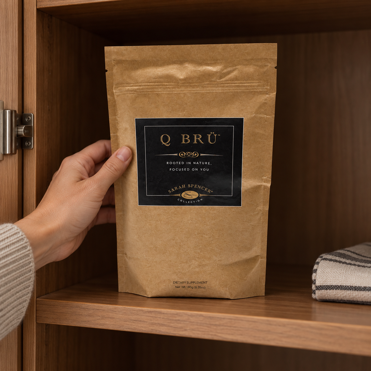 Q BRÜ pouch being placed on a shaded kitchen cabinet shelf