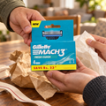 Adults handing over one Gillette Mach3 Fresh Clean 4-count refill pack with gift wrapping.