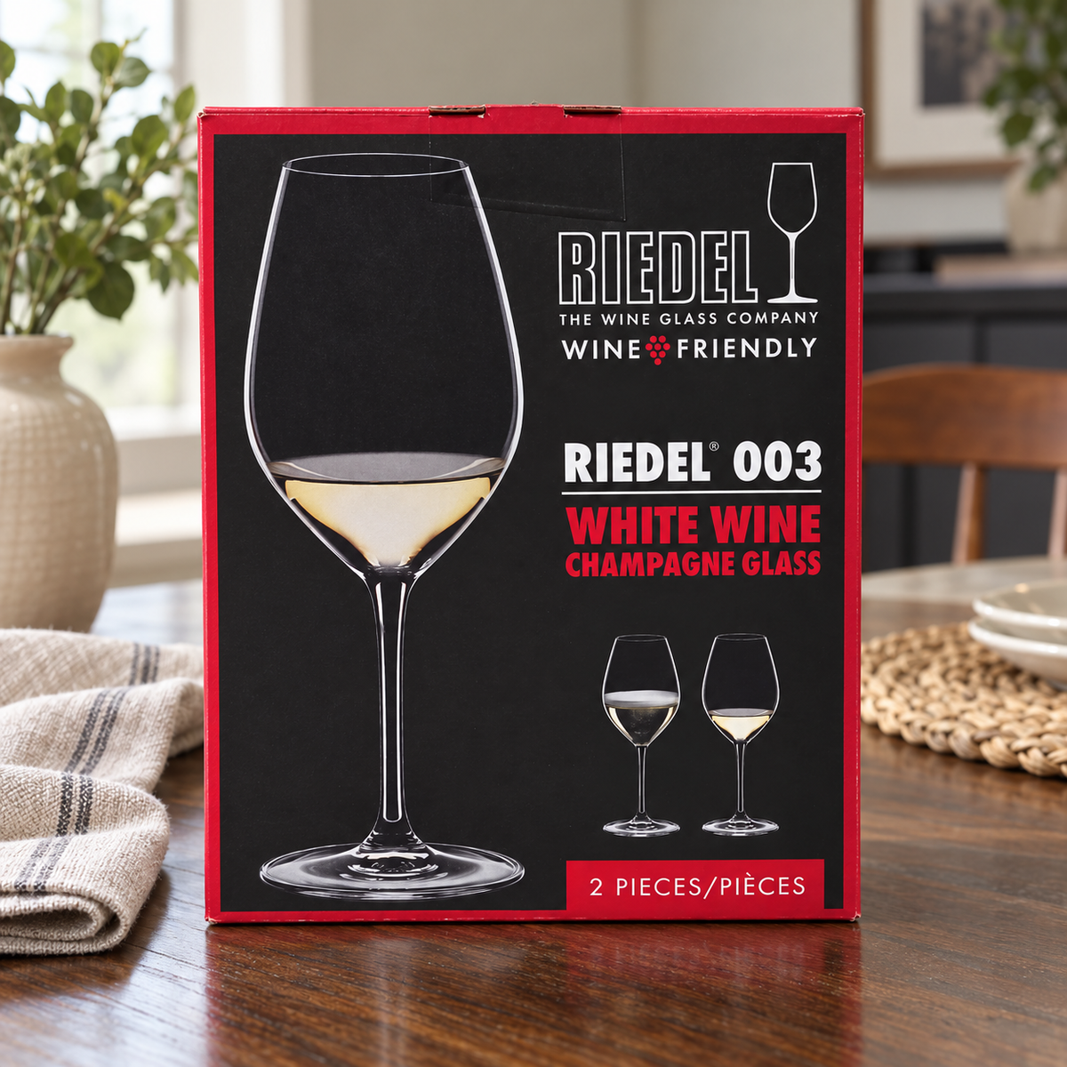 AI-generated lifestyle scene of one closed Riedel 003 White Wine Champagne Glass two-piece box on a dining table. Props not included.