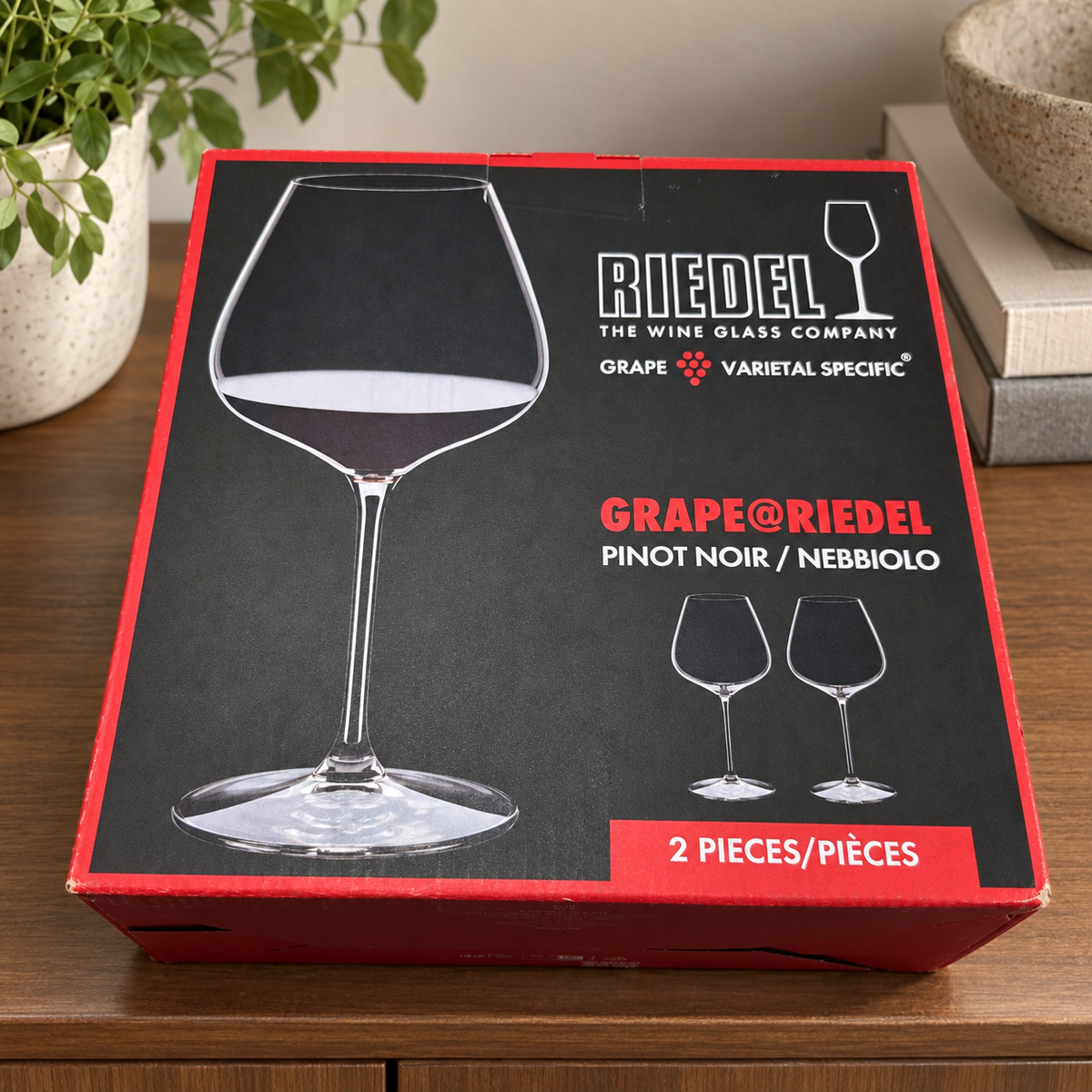 AI-generated lifestyle scene of one closed GRAPE@RIEDEL Pinot Noir Nebbiolo two-piece box on a cabinet shelf. Props not included.