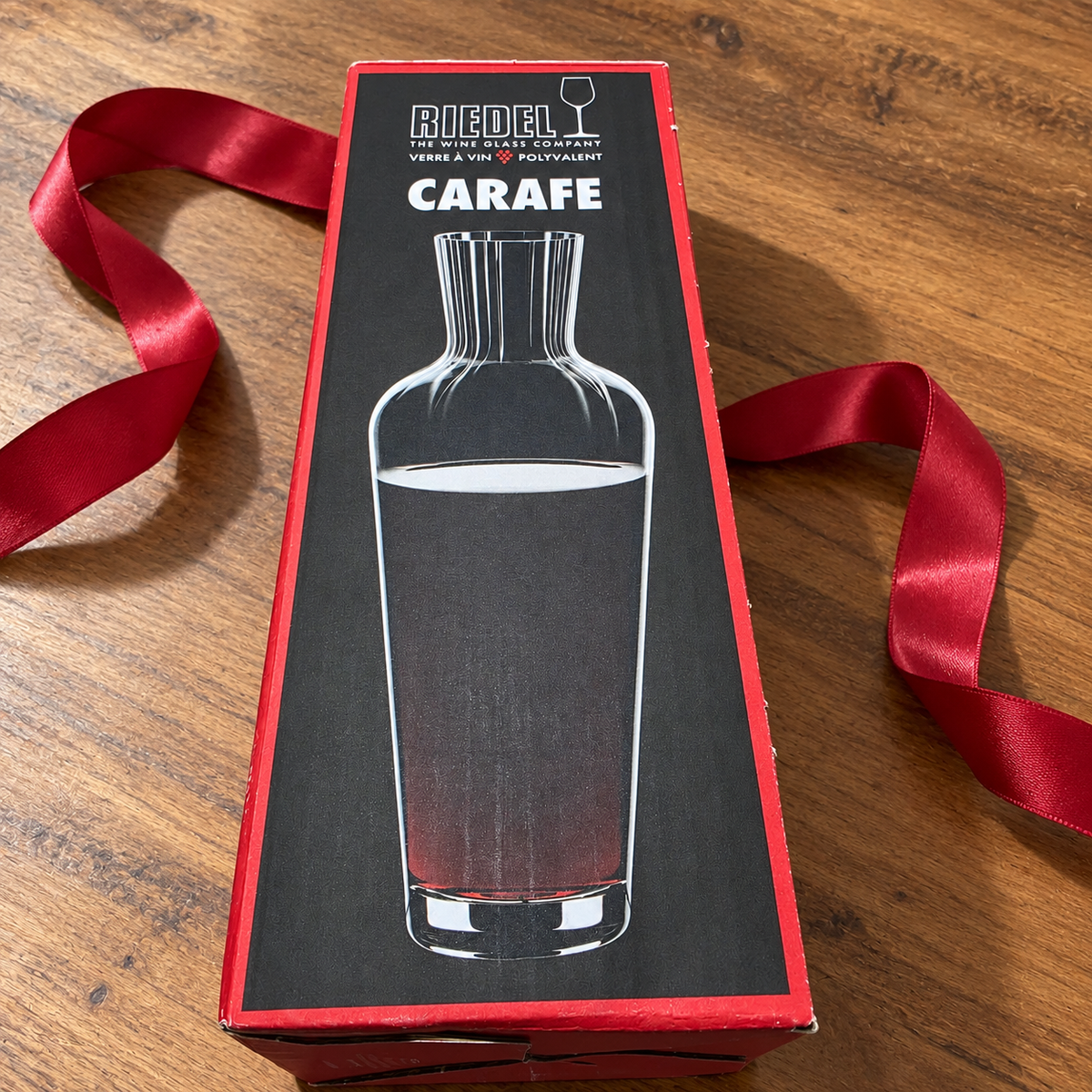 AI-generated lifestyle scene of one closed Riedel Wine Friendly carafe retail box on a gift table. Props not included.
