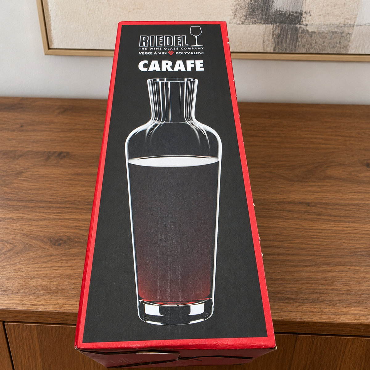 AI-generated lifestyle scene of one closed Riedel Wine Friendly carafe retail box on a sideboard. Props not included.
