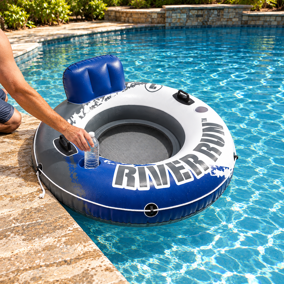 Placing a water bottle in the blue cup holder of an Intex River Run tube by the pool