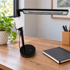 AI-generated lifestyle illustration of an unlit black Room and Retreat LED desk lamp in an office desk setting. Tag reverse shown; props not included.