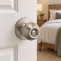 Safe Lock by Kwikset Regina Satin Nickel privacy knob on a white bedroom door, lifestyle illustration