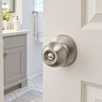 Regina Satin Nickel privacy knob installed on a bright bathroom door, lifestyle illustration