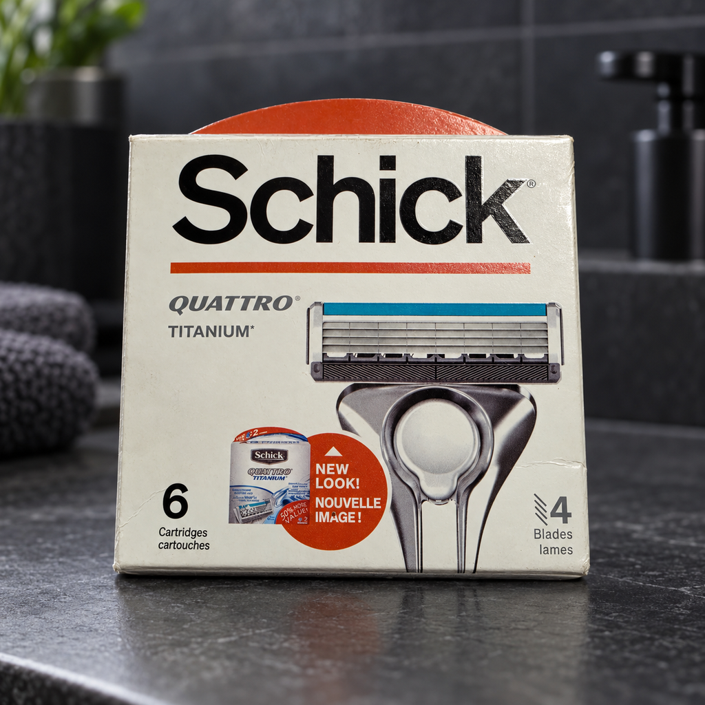 Illustrative lifestyle view of one Schick Quattro Titanium six-cartridge refill box against charcoal bathroom tile