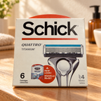 Illustrative lifestyle view of one Schick Quattro Titanium six-cartridge refill box on a warm oak bathroom vanity