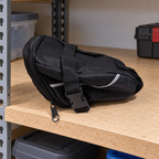 AI-generated lifestyle illustration of the closed unmounted black Schwinn seat pack on an equipment shelf; background props not included.