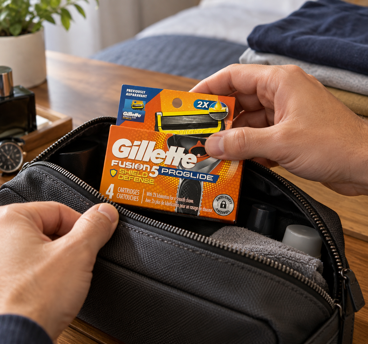 One Gillette ProGlide Shield four-refill pack being placed into a travel toiletry bag.