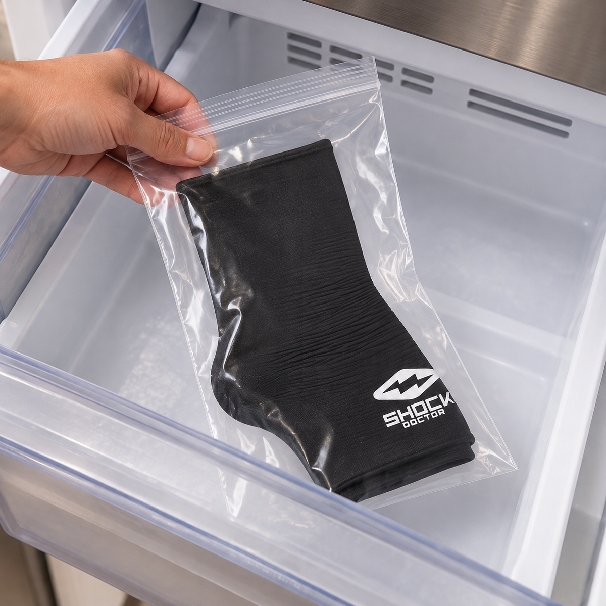 Placing the dry Shock Doctor Flex Ice ankle sleeve flat in its protective bag in a freezer