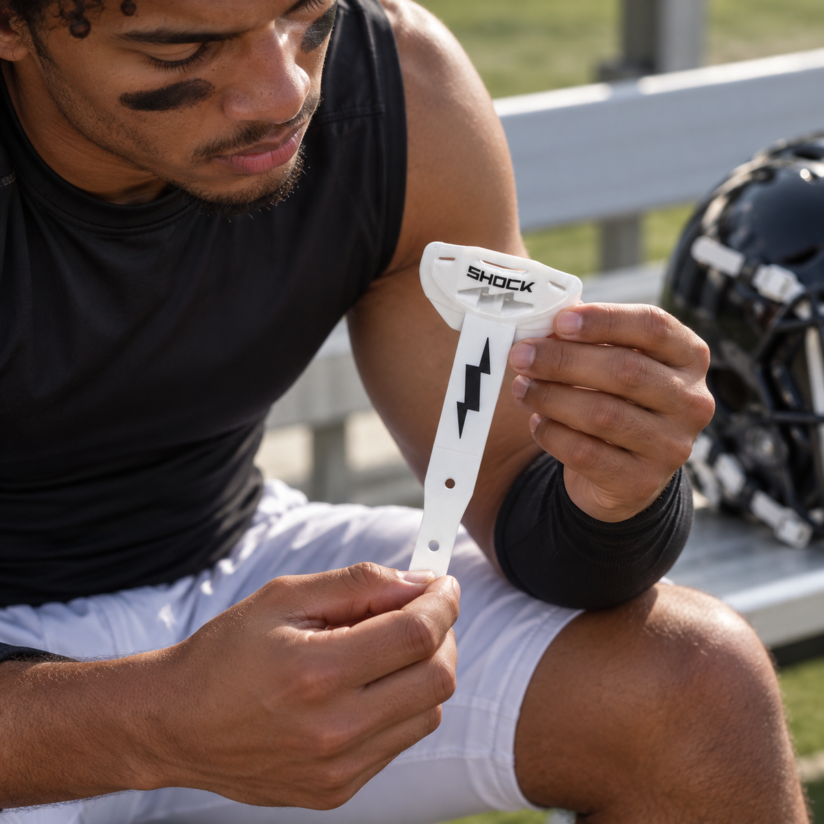 Checking a white Shock Doctor Thunder Bolt lip guard and strap before practice