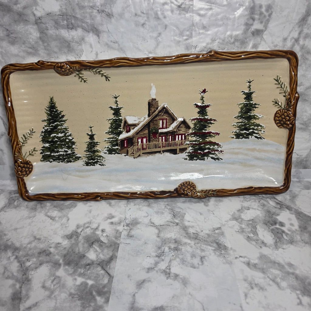 St. Nicholas Square Snow Valley rectangular platter with snowy cabin and raised brown pinecone border