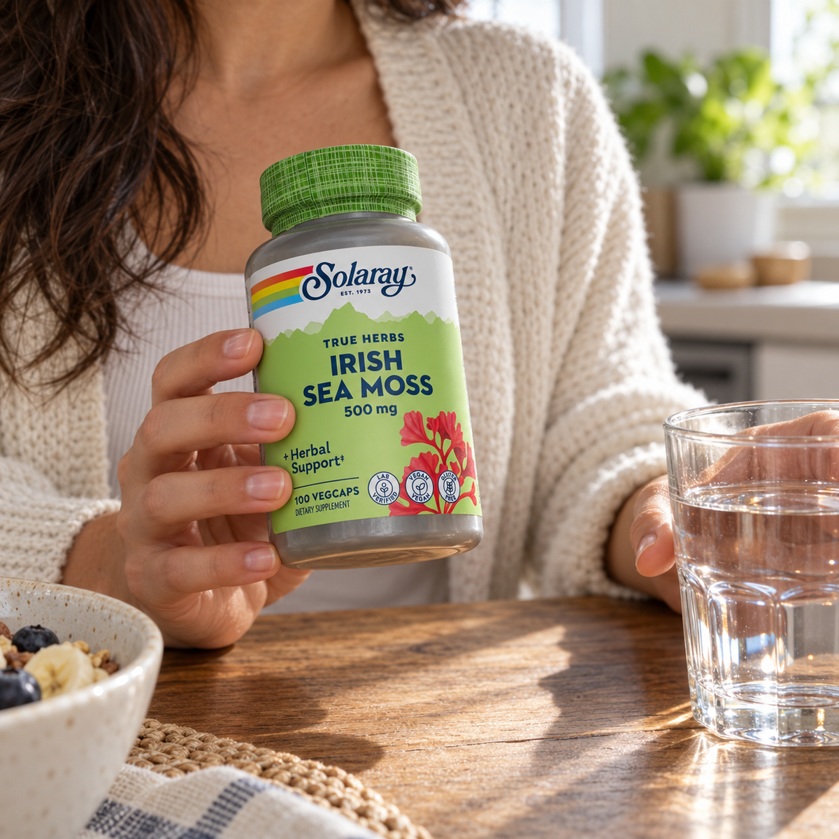 Solaray Irish Sea Moss bottle held at the breakfast table with water