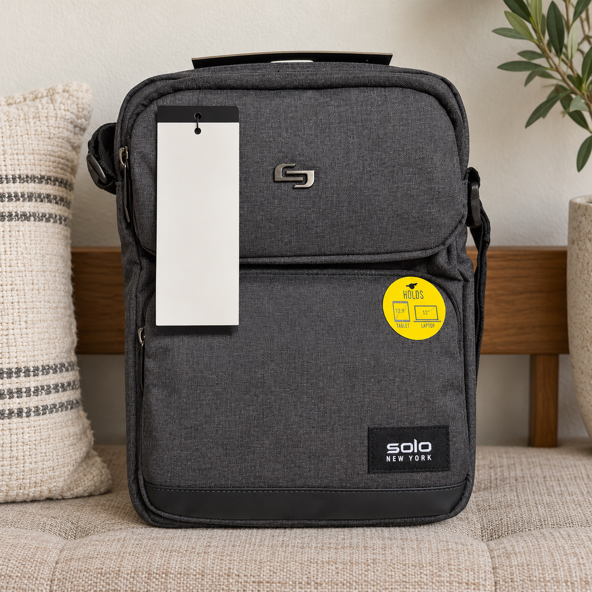 AI-generated lifestyle scene of the closed gray Solo New York Ludlow tablet sling on an entry bench. Props not included; hangtag shown from reverse.