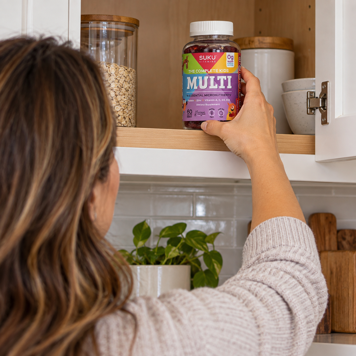Adult storing SUKU Kids Multi on a high kitchen shelf