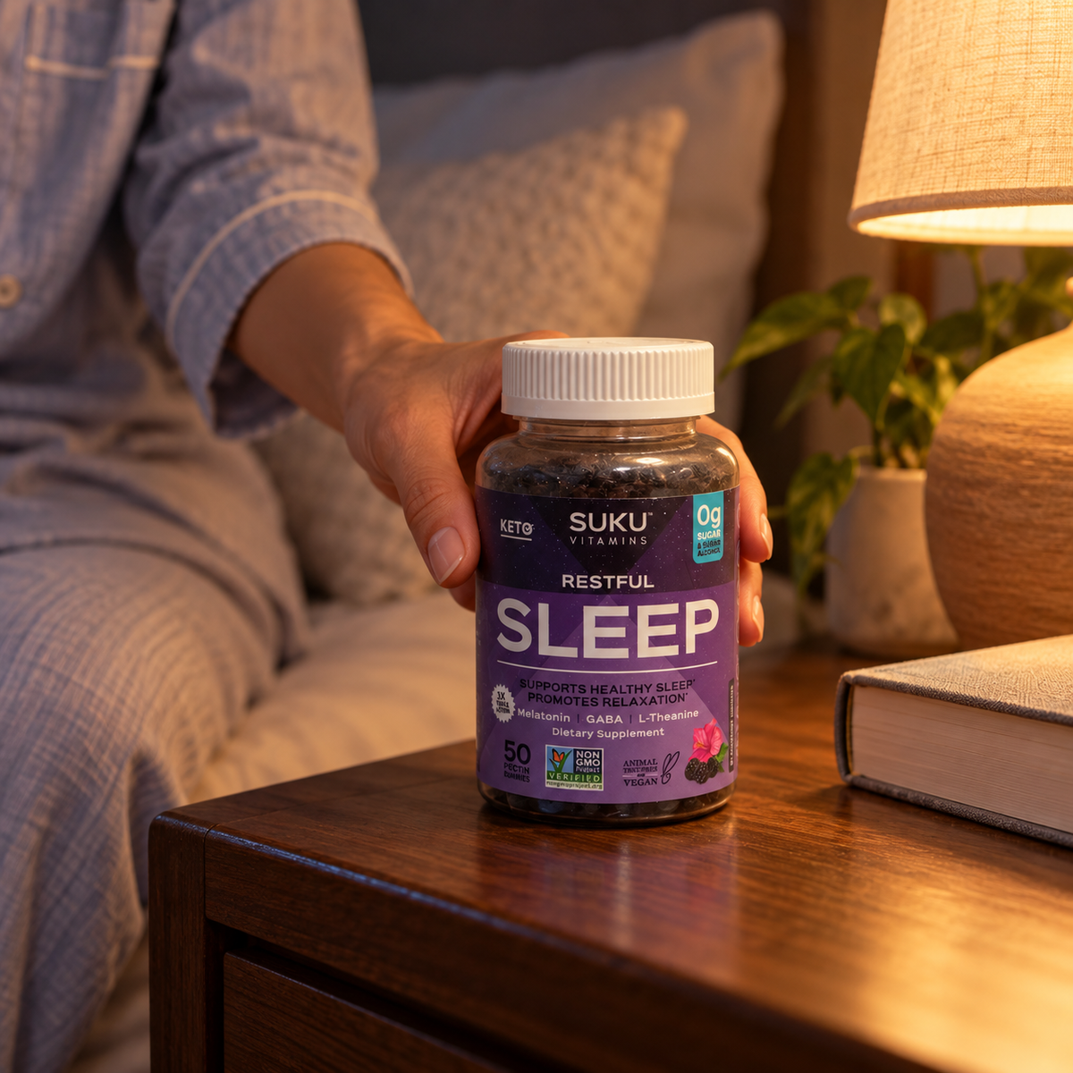 Adult placing SUKU Restful Sleep beside a bedside lamp