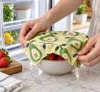 AI-generated lifestyle illustration: Green pear-print SuperBee wrap covering a fruit bowl; food and props not included.
