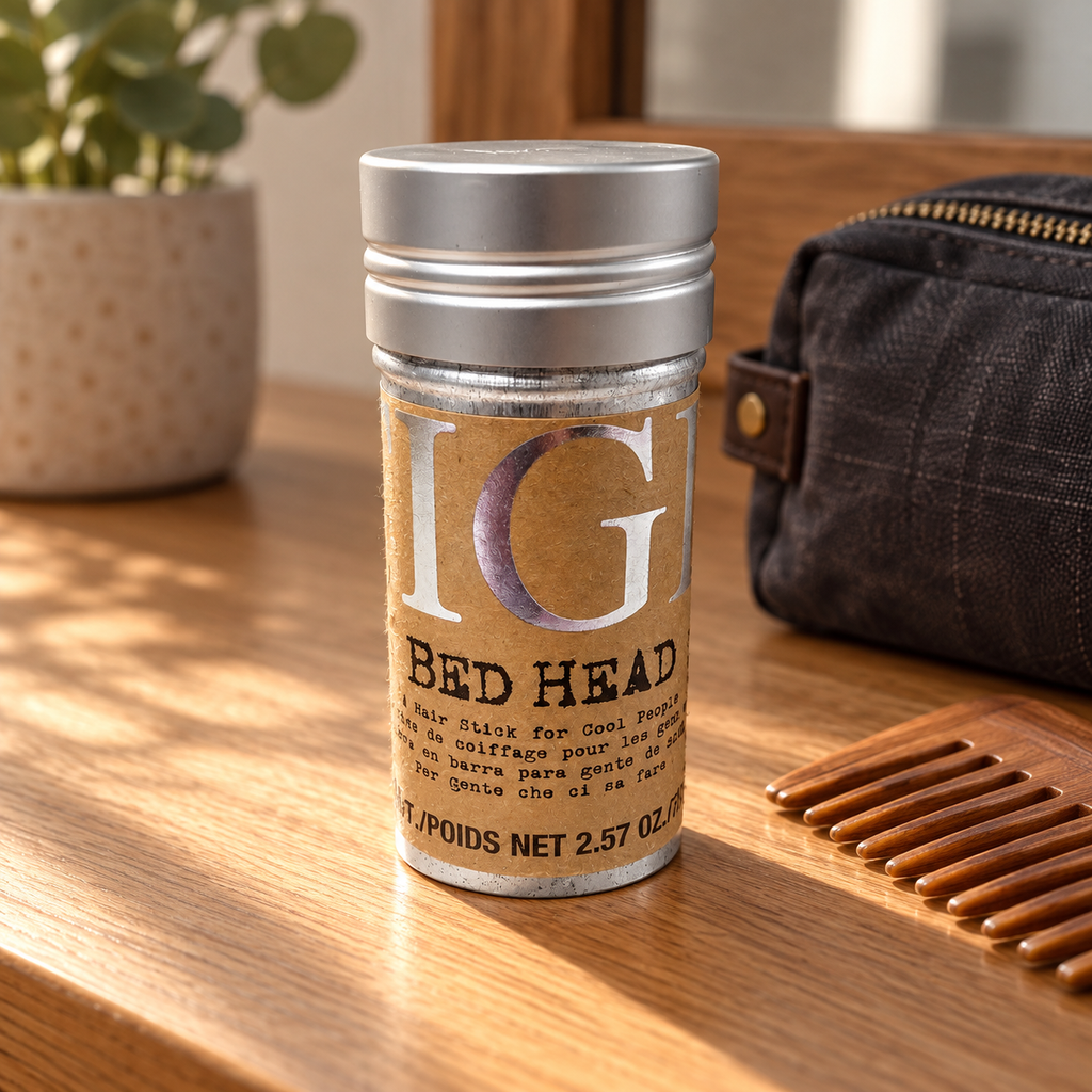 Illustrative TIGI Bed Head Hair Stick on an oak dressing table with a toiletry pouch and comb; background props not included