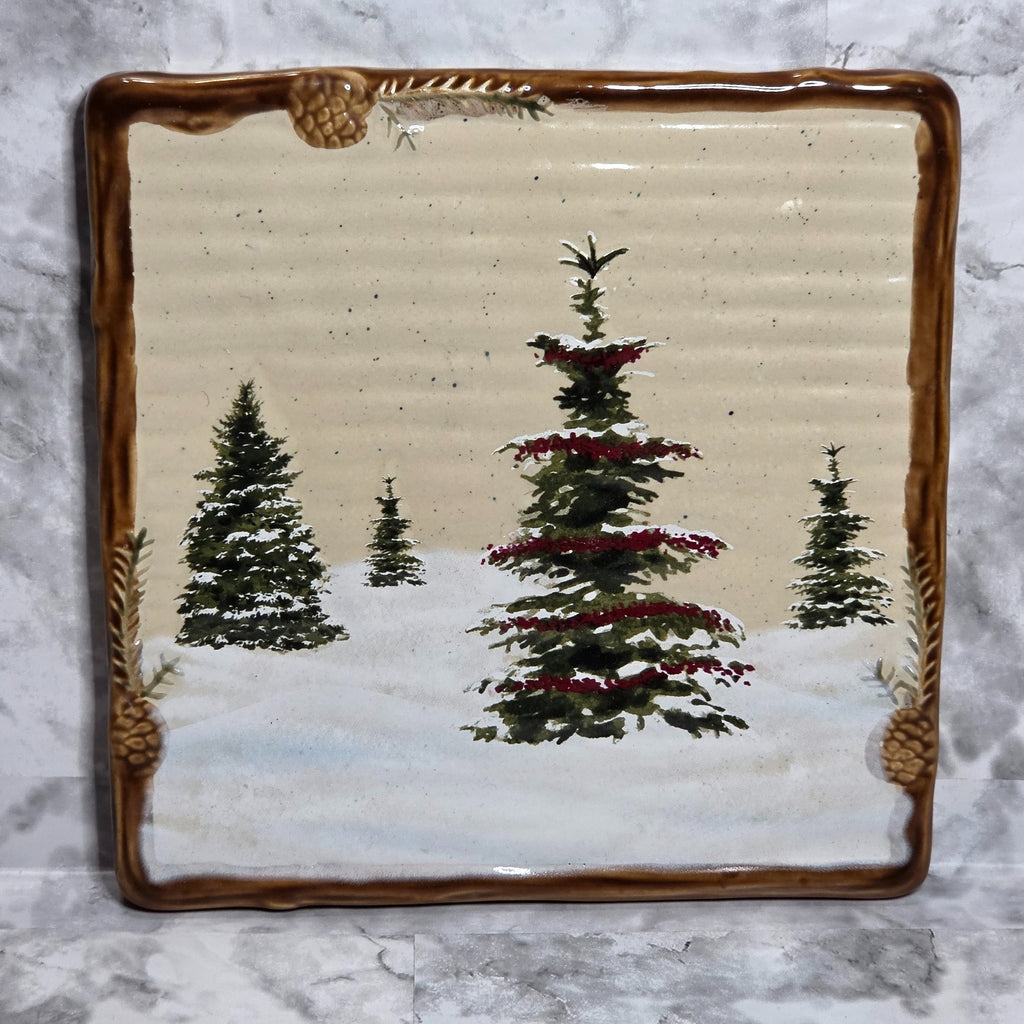 St. Nicholas Square Snow Valley square trivet with snowy Christmas trees and brown pinecone border