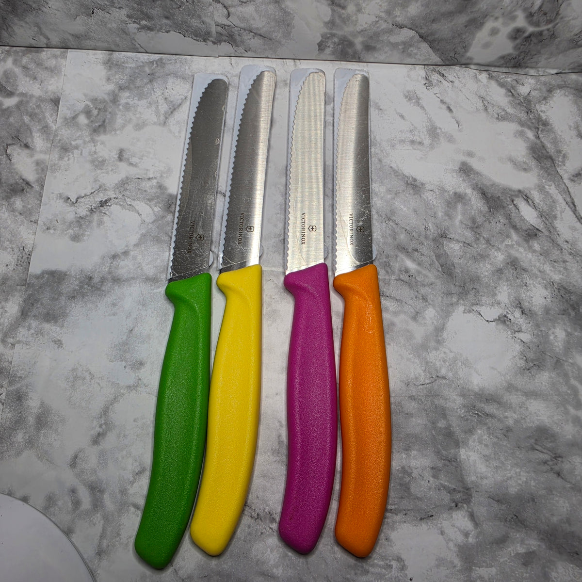 Actual Victorinox Swiss Classic serrated knife set of four with green, yellow, pink, and orange handles