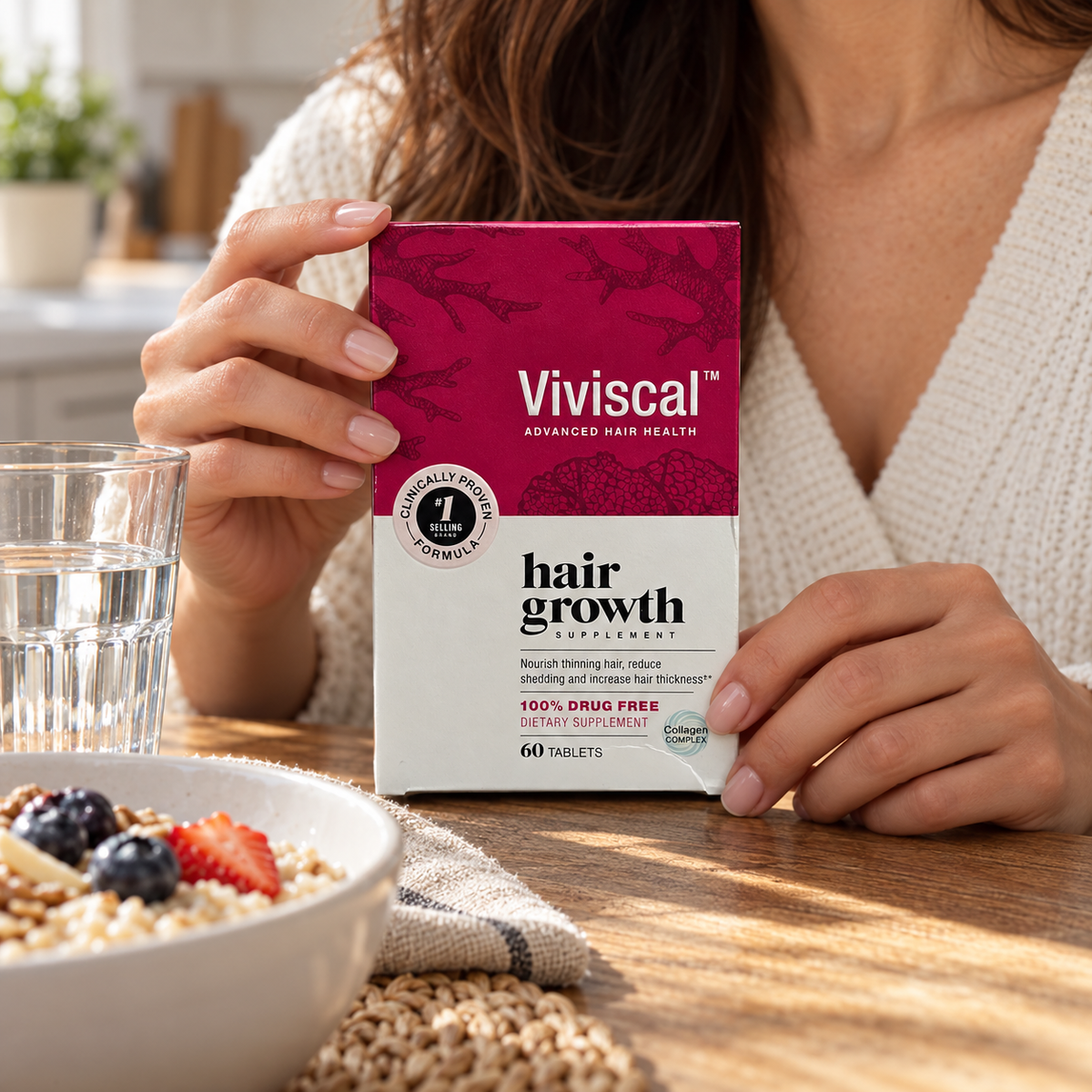 Viviscal Advanced Hair Health carton held beside breakfast and a glass of water