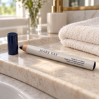 Mary Kay Weekender Classic Navy eye pencil and cap on a pale stone bathroom tray