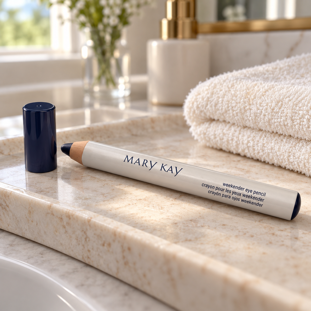 Mary Kay Weekender Classic Navy eye pencil and cap on a pale stone bathroom tray