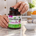 Adult opening a Wellements Organic Multivitamin Gummies bottle