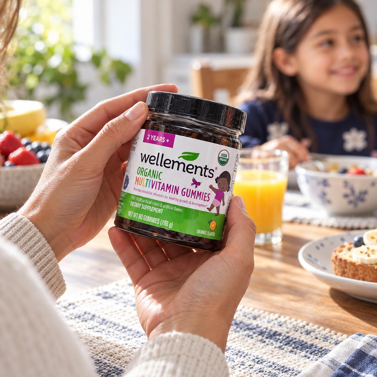Caregiver holding Wellements gummies during a family breakfast routine