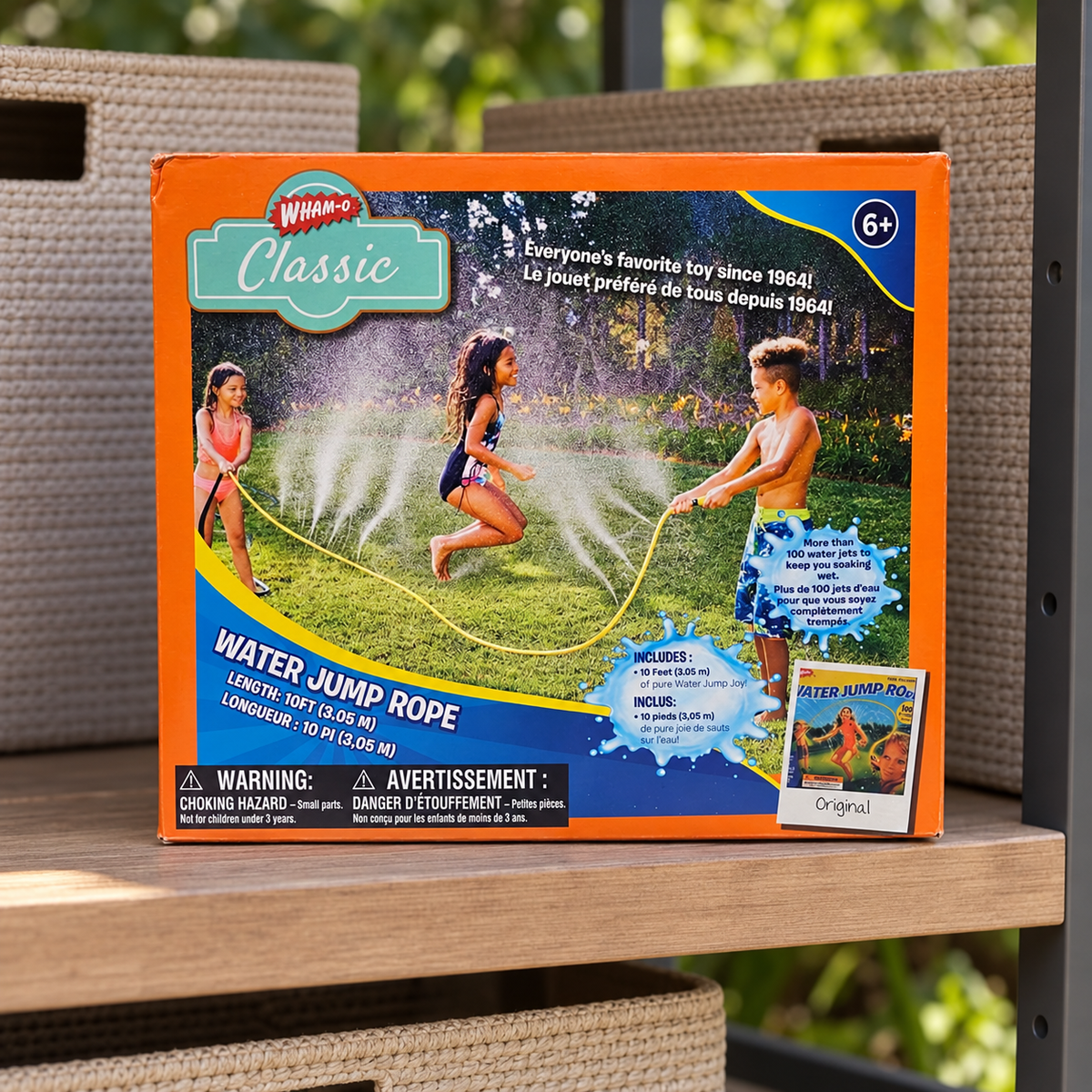 AI-generated lifestyle scene of one closed Wham-O Classic Water Jump Rope box on a toy storage shelf. People and water appear only in printed packaging artwork; props not included.