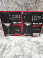 Two Riedel wine glass boxes on a marble surface