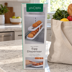 AI-generated lifestyle illustration of one closed youCopia RollDown Egg Dispenser box in a grocery tote setting. Background props not included.