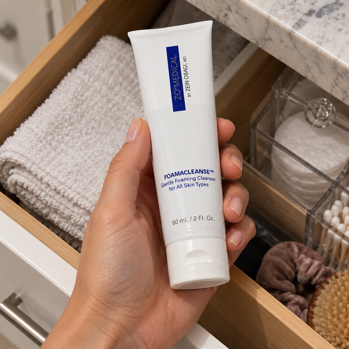 AI-staged scene: Adult taking ZO Medical Foamacleanse 60 mL from a bathroom drawer; props not included.